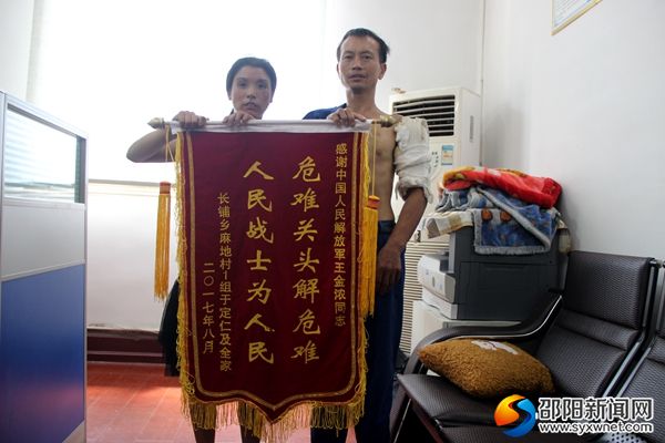 于定仁与妻子制作锦旗感谢助人者王金浓