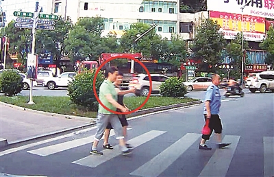 过斑马线的女士为让行车辆竖起了大拇指。