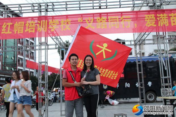 图为志愿者在义卖现场为爱人鲜花过七夕