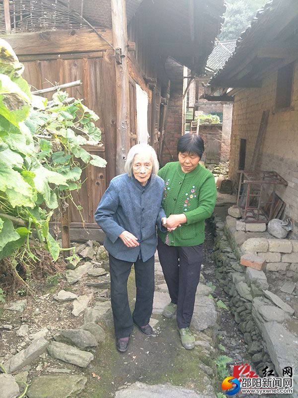 谢桂英扶双目失明邻居外出晒天阳