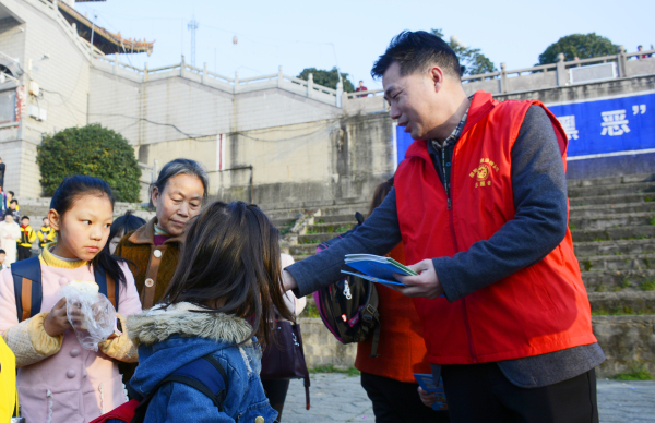 志愿者向学生发放宣传资料。.jpg