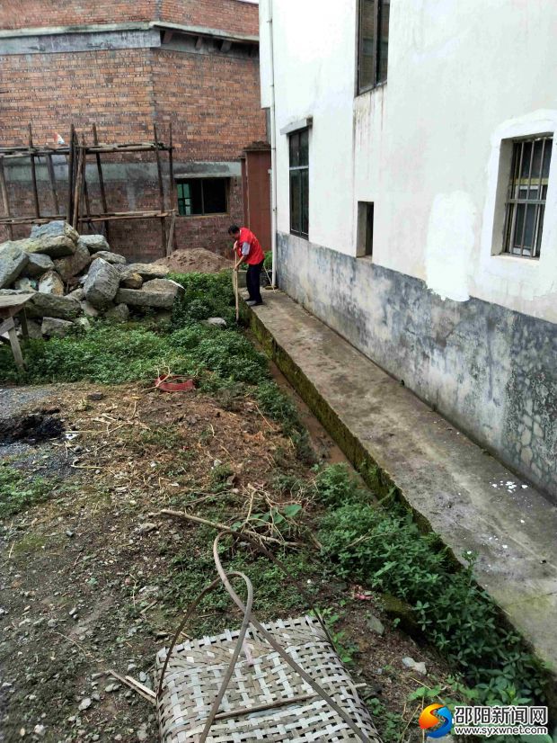 志愿者清理贫困户房屋臭水沟