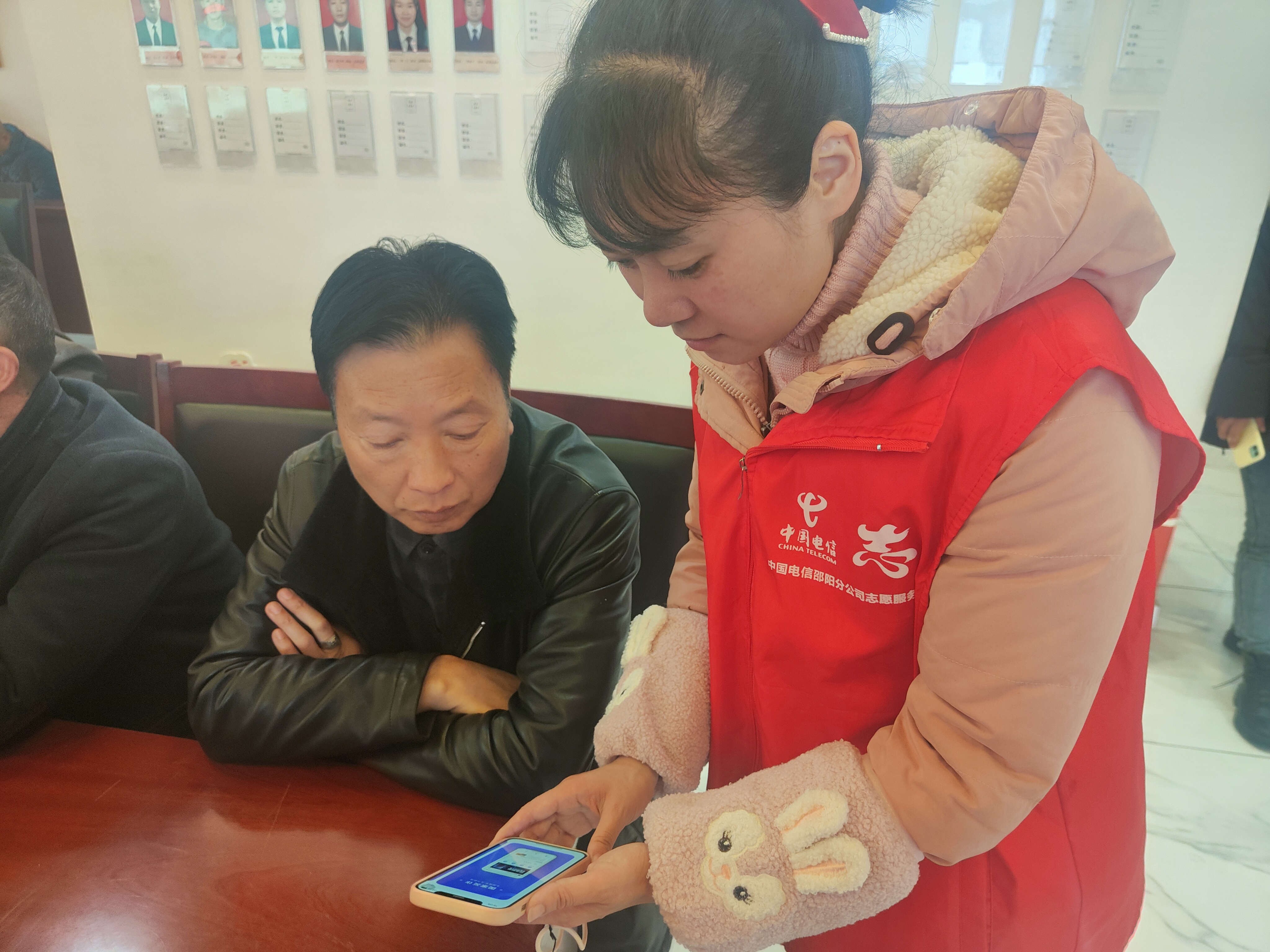 邵阳分公司志愿者为居民介绍国家反诈中心APP.jpg