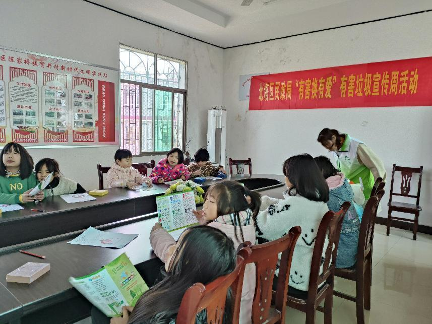 志愿者现场为小朋友讲解有害垃圾的危害.png