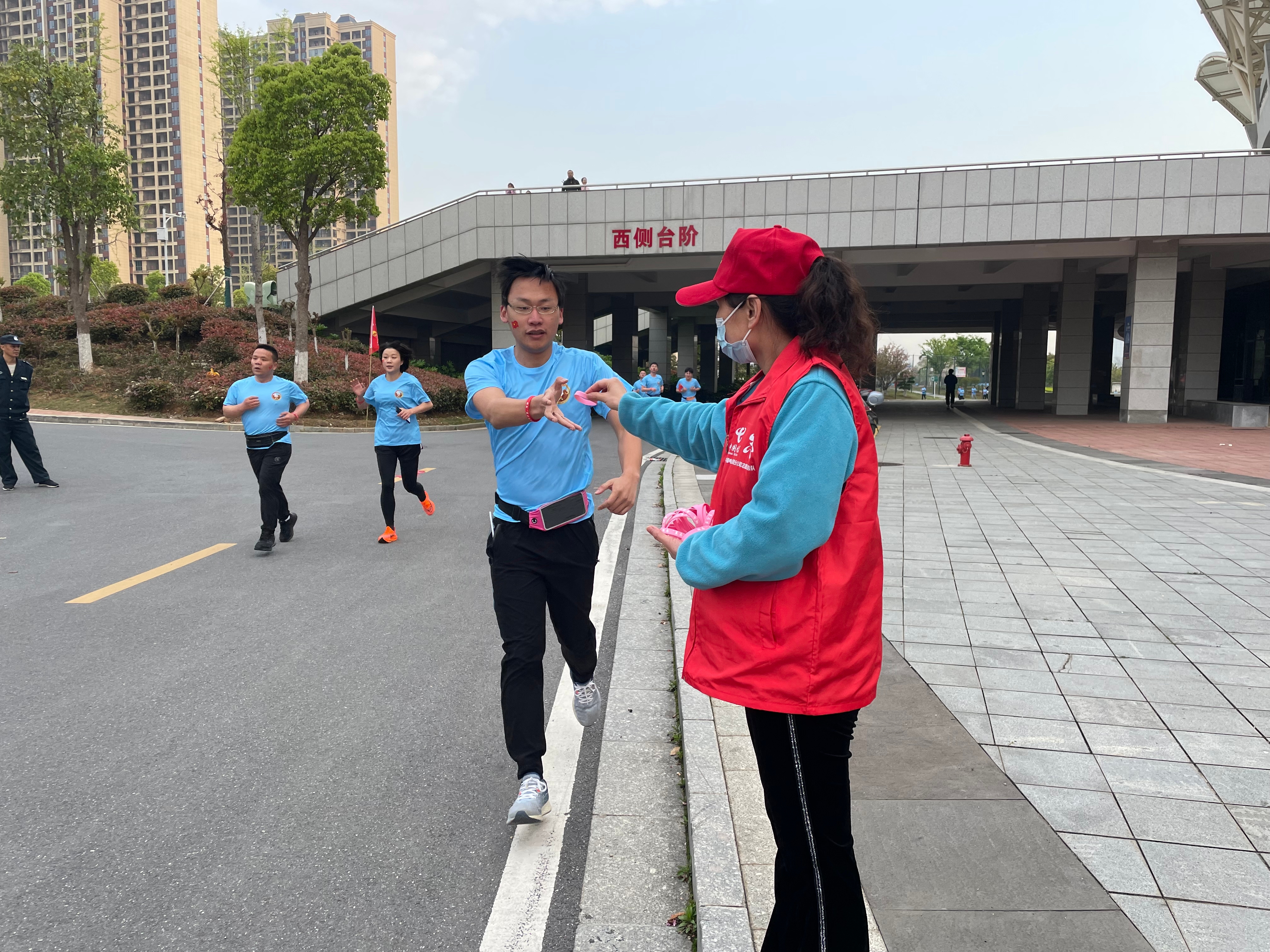 7、电信“小翼”志愿者在迷你马拉松比赛现场向运动员发放手环为运动员加油.jpg