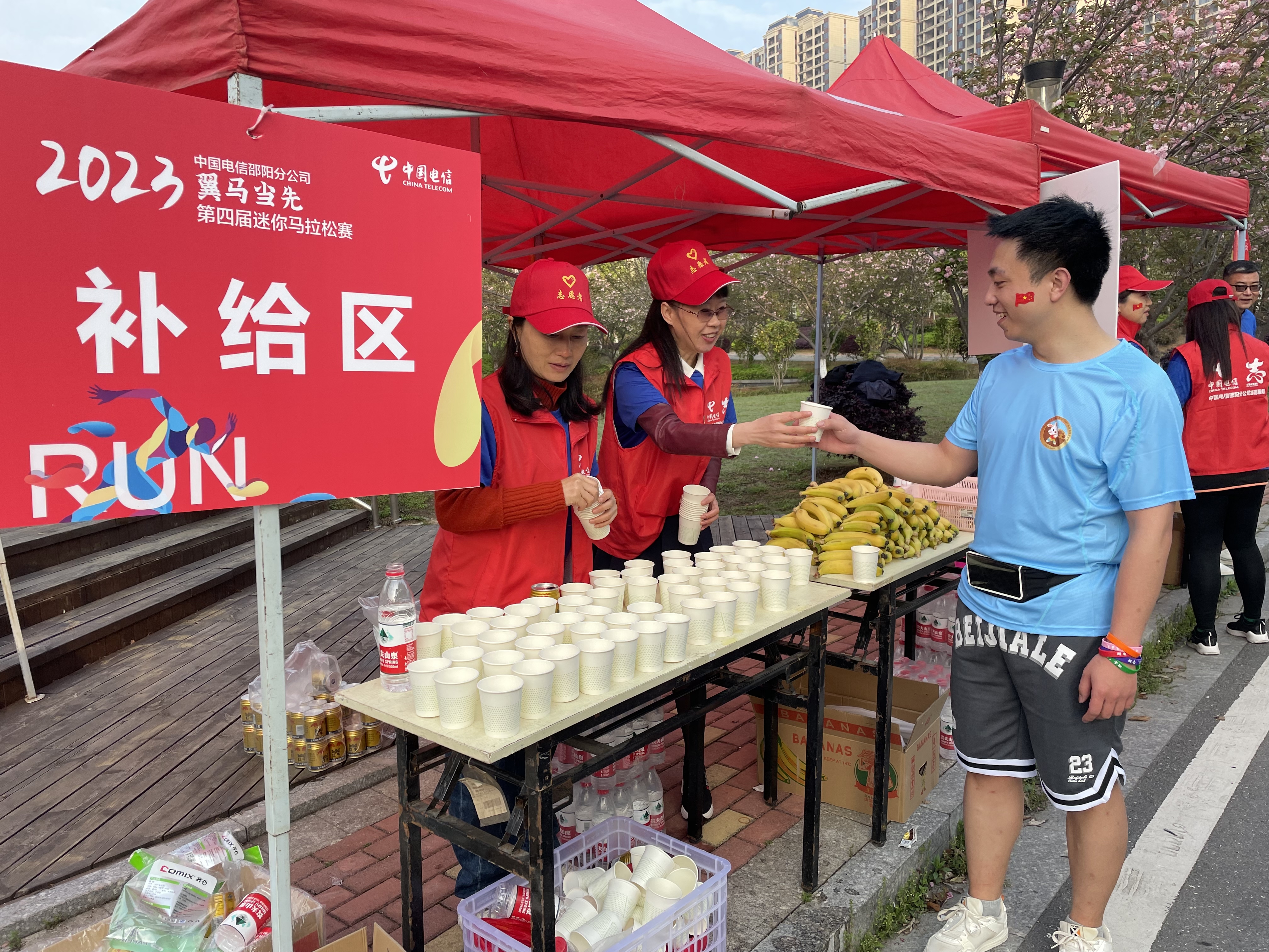 5、电信“小翼”志愿者在补给区为运动员服务.jpg