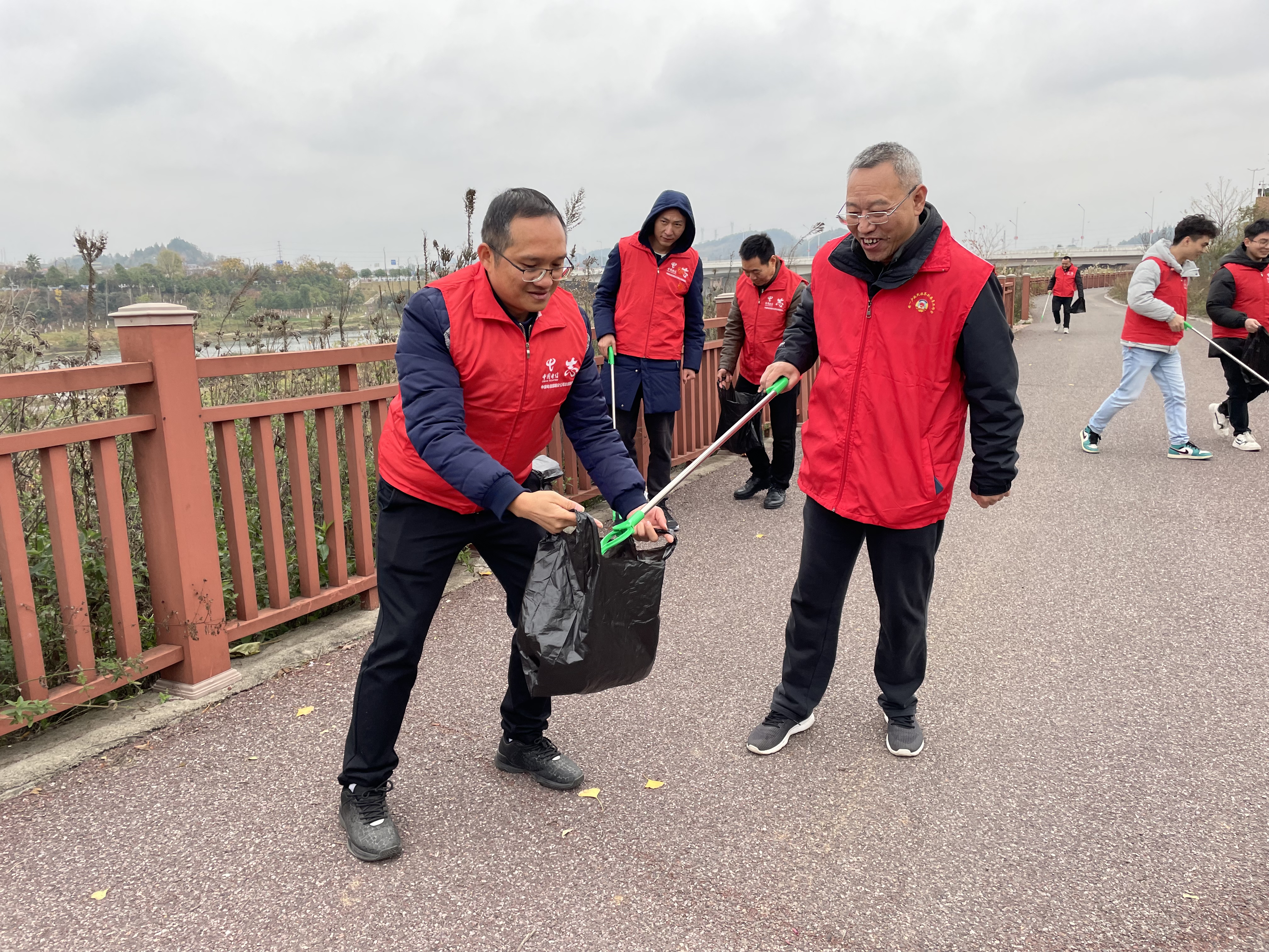邵阳市政协领导与电信志愿者一起清理体育新城河畔垃圾.jpg