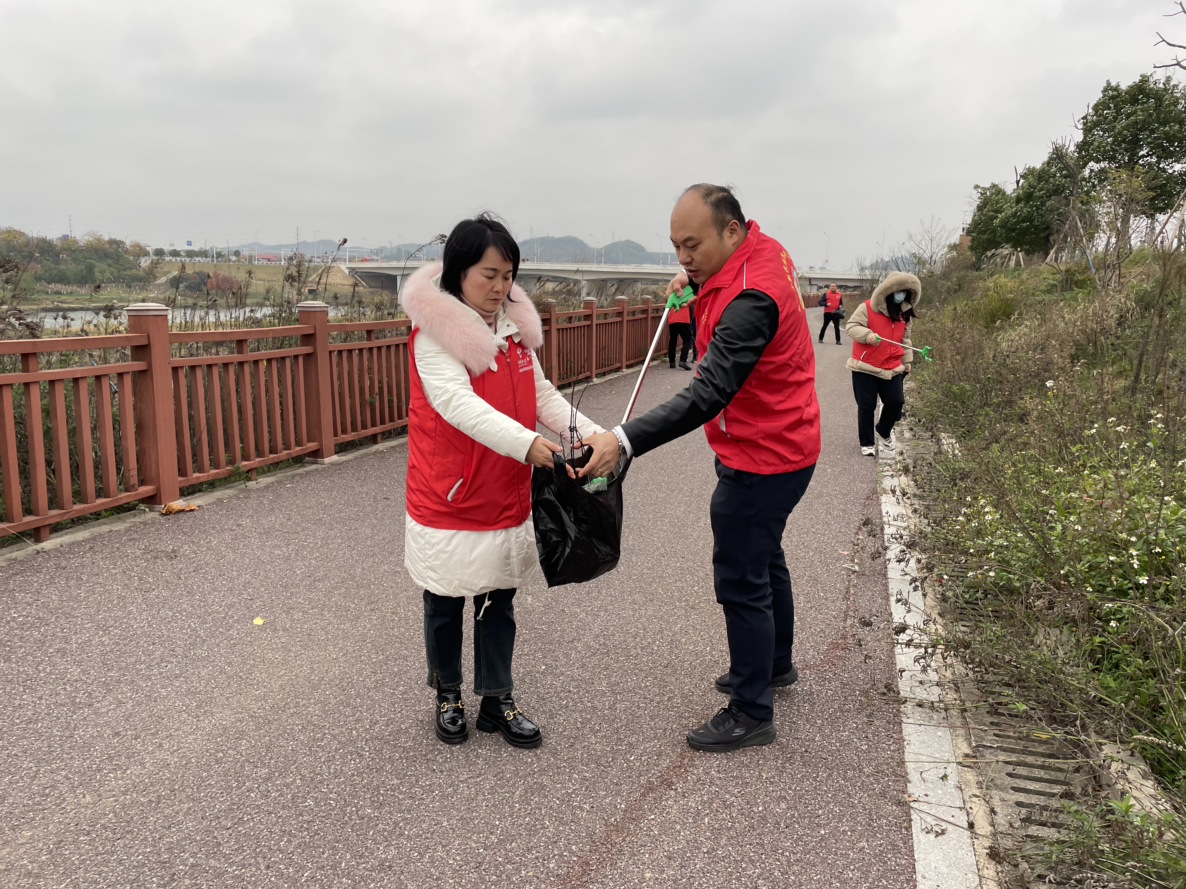 邵阳市政协委员、工会主席、副总经理黄费秋与志愿者一起捡拾河畔垃圾.jpg
